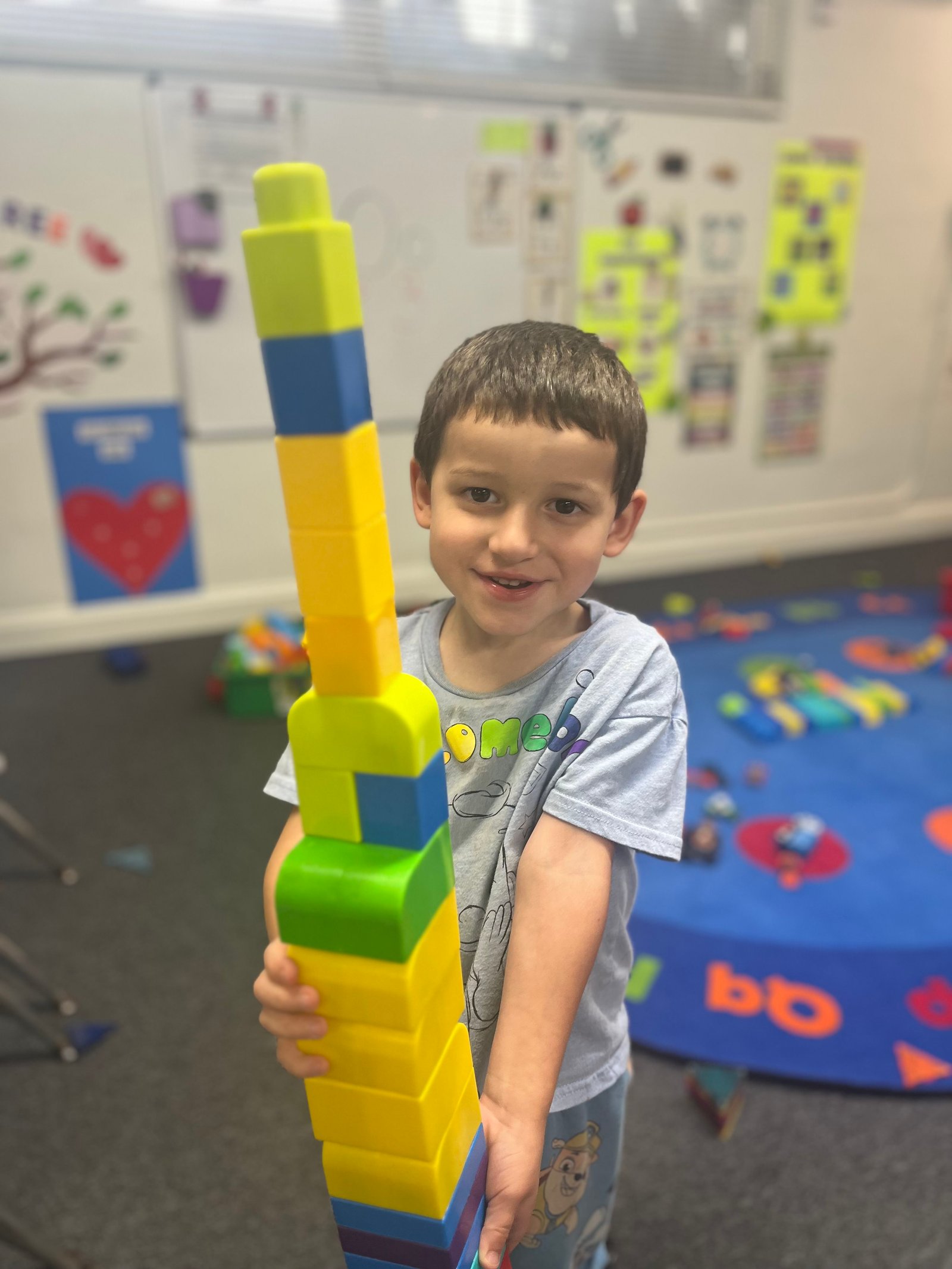 Child proudly holding colorful blocks